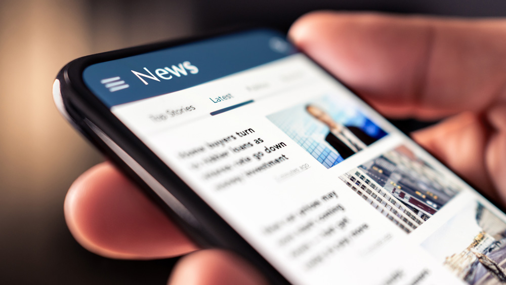 person scrolling news articles on a smartphone