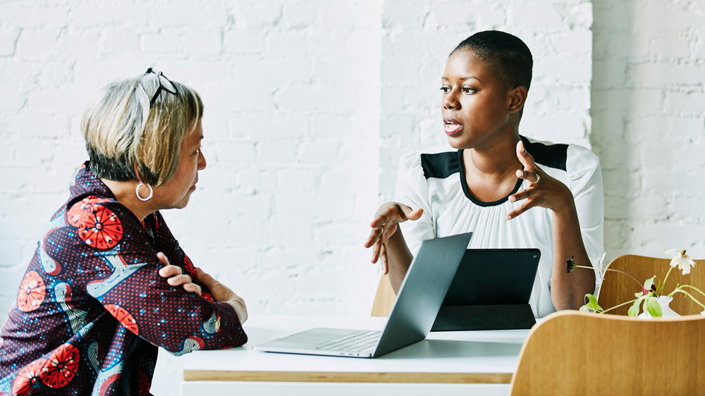 female consultant having conversation with female client in relaxed office space