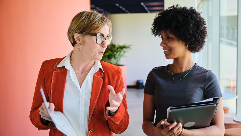 professor and student walking down hallway talking