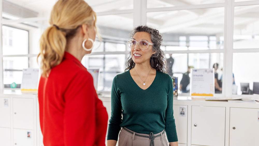 two women talking in office environment