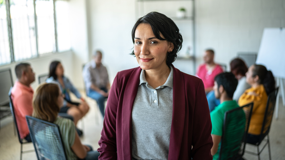 corporate trainer standing in front of room full of participants