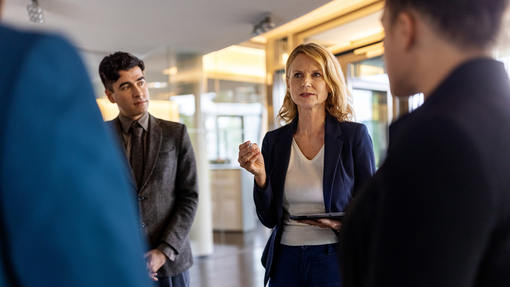 confident and stern female ceo with group of executives